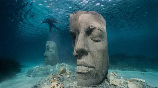 潜水者在向海底雕塑游去